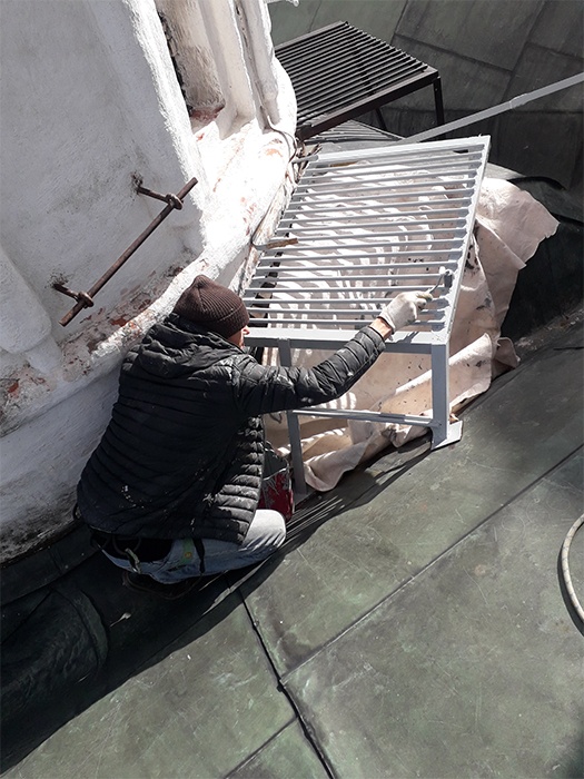 Покраска поверхности металлической поверхности мостков крыши церкви Двенадцати апостолов